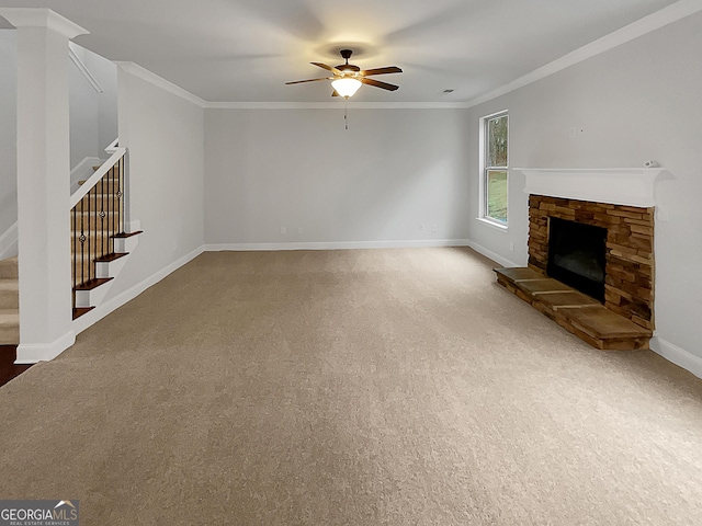 unfurnished living room with crown molding, carpet floors, ceiling fan, and a fireplace