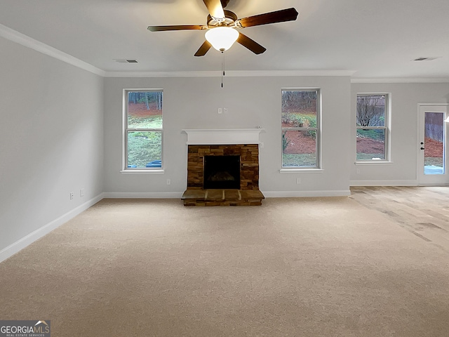 unfurnished living room with crown molding, ceiling fan, a fireplace, and carpet floors