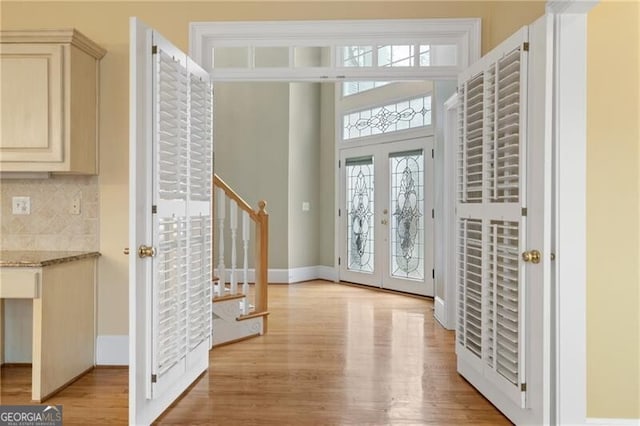 entryway with light hardwood / wood-style floors and french doors