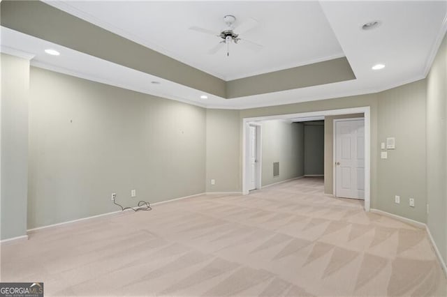 carpeted empty room with a tray ceiling, ornamental molding, and ceiling fan