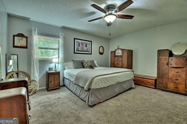 carpeted bedroom with ceiling fan and a textured ceiling