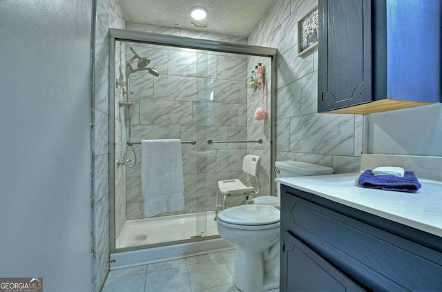 bathroom with tile walls, vanity, walk in shower, toilet, and a textured ceiling