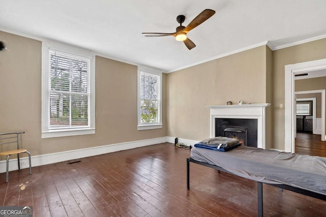 living room featuring dark hardwood / wood-style flooring, crown molding, and ceiling fan