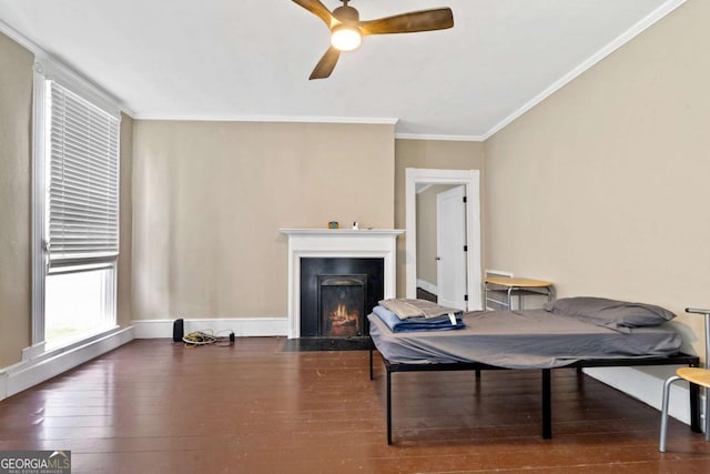 living area featuring dark wood-type flooring, ceiling fan, and ornamental molding