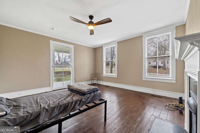 bedroom featuring ceiling fan, ornamental molding, and dark hardwood / wood-style floors