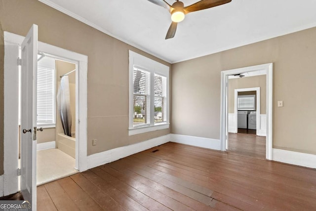 unfurnished bedroom with washer / clothes dryer, wood-type flooring, and crown molding