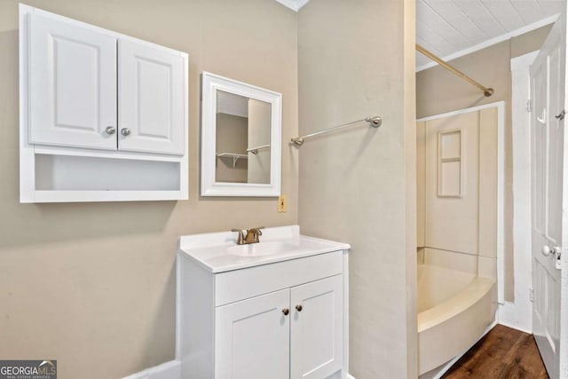 bathroom with hardwood / wood-style flooring, vanity, and  shower combination