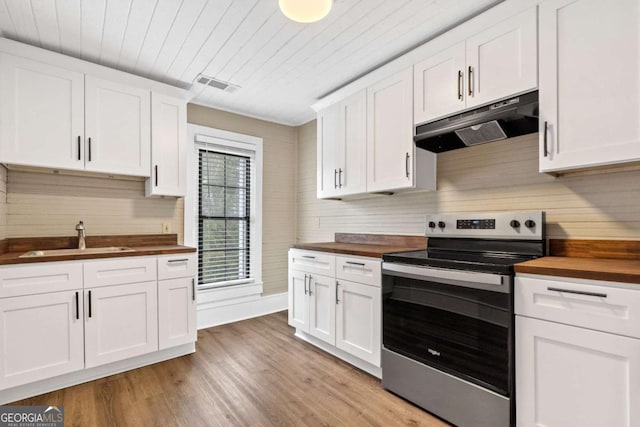 kitchen featuring white cabinetry, wooden counters, sink, and stainless steel range with electric cooktop