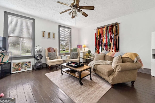 living area featuring ceiling fan, dark hardwood / wood-style floors, and a textured ceiling