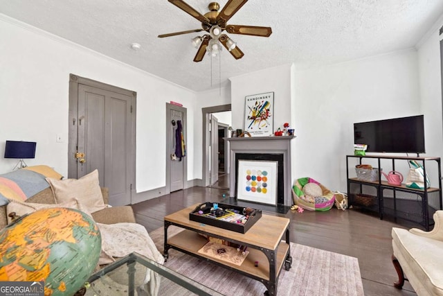 living room with dark hardwood / wood-style flooring, ceiling fan, crown molding, and a textured ceiling