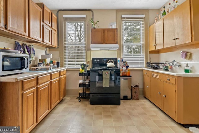 kitchen with a wealth of natural light, a textured ceiling, and black range with electric cooktop