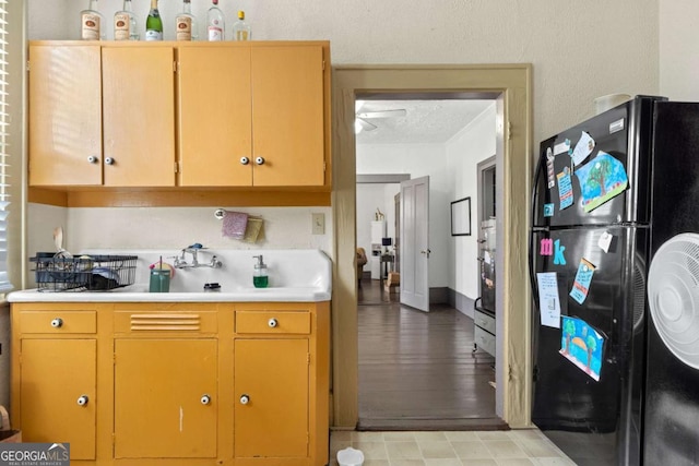 kitchen featuring black refrigerator and a textured ceiling