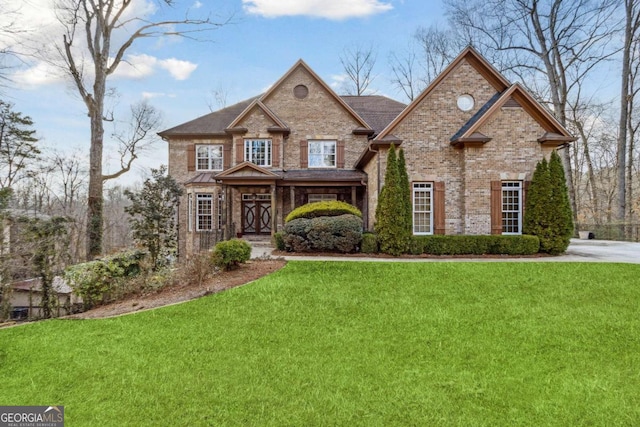 view of front facade featuring brick siding and a front yard