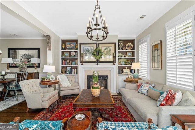 122 Brighton Blvd, Woodstock, GA 30188 - living room with a glass covered fireplace, a notable chandelier, crown molding, visible vents, and wood finished floors