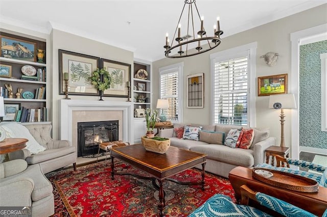 122 Brighton Blvd, Woodstock, GA 30188 - living area with a glass covered fireplace, baseboards, an inviting chandelier, crown molding, and built in shelves