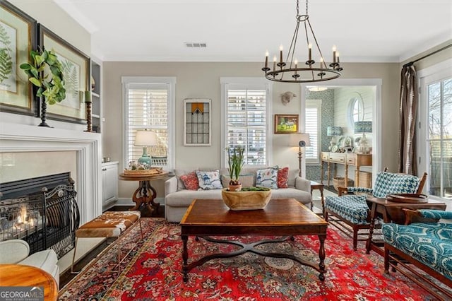 122 Brighton Blvd, Woodstock, GA 30188 - living area featuring visible vents, an inviting chandelier, a lit fireplace, wood finished floors, and ornamental molding