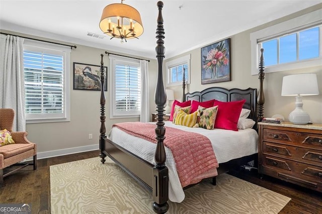 122 Brighton Blvd, Woodstock, GA 30188 - bedroom with dark wood-style flooring, a notable chandelier, visible vents, and baseboards