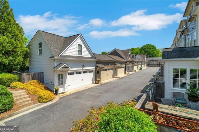 122 Brighton Blvd, Woodstock, GA 30188 - view of property exterior featuring fence, aphalt driveway, and a garage