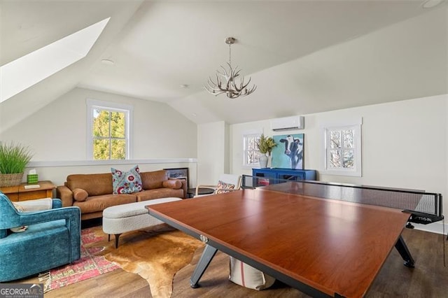 122 Brighton Blvd, Woodstock, GA 30188 - playroom featuring vaulted ceiling with skylight, wood finished floors, an inviting chandelier, and an AC wall unit