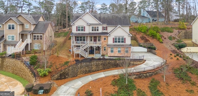 view of front of house featuring board and batten siding, driveway, and stairway