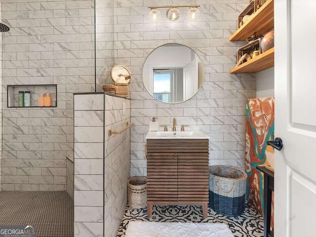 bathroom featuring walk in shower, vanity, and tile walls