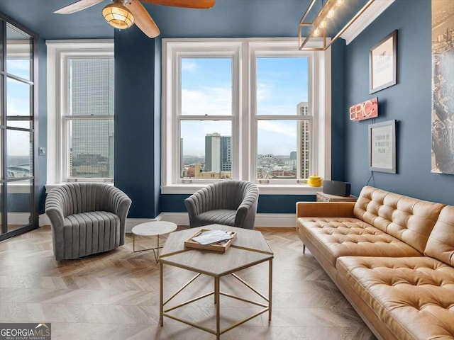 sitting room with ceiling fan and light parquet flooring