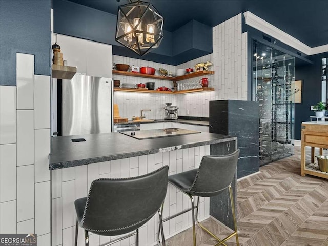 bar featuring parquet flooring, sink, appliances with stainless steel finishes, a notable chandelier, and white cabinets