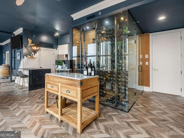 wine cellar featuring parquet flooring and ornamental molding