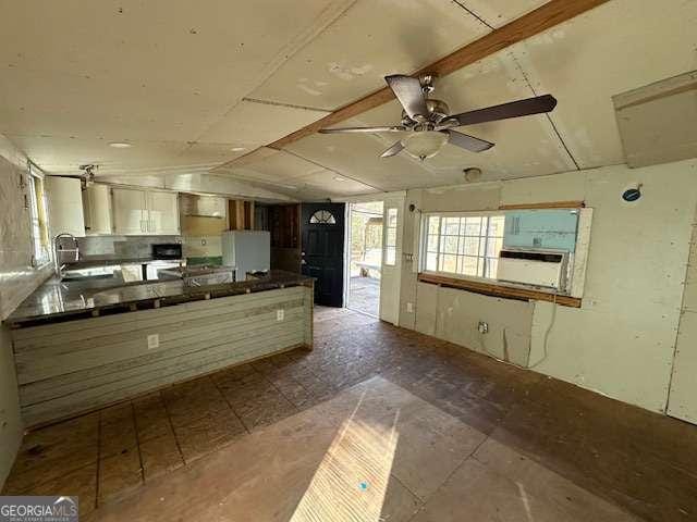 kitchen with sink, vaulted ceiling, white fridge, cooling unit, and ceiling fan