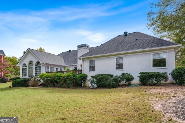 rear view of property featuring a lawn