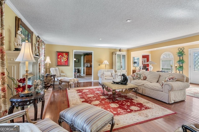 living room featuring hardwood / wood-style flooring, crown molding, and a textured ceiling