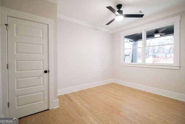 spare room with ceiling fan, ornamental molding, and light hardwood / wood-style flooring