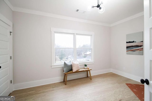 living area with ornamental molding and hardwood / wood-style floors