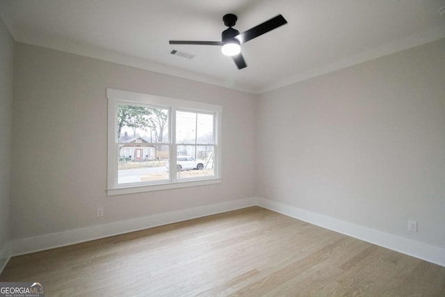 empty room featuring ornamental molding, ceiling fan, and light wood-type flooring