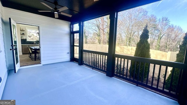 unfurnished sunroom featuring ceiling fan