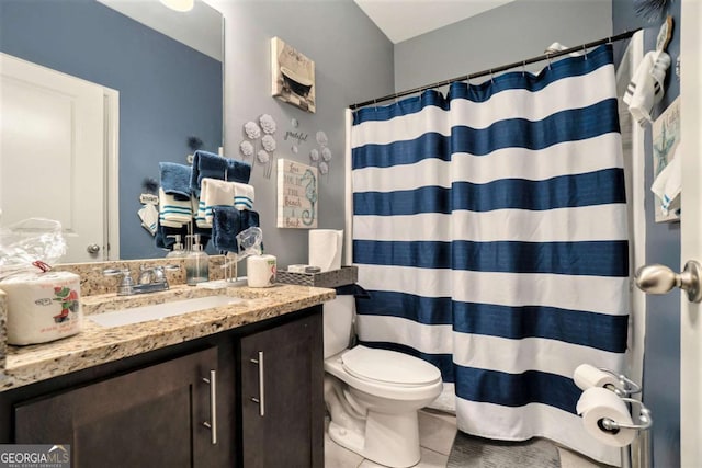 bathroom featuring tile patterned flooring, vanity, curtained shower, and toilet