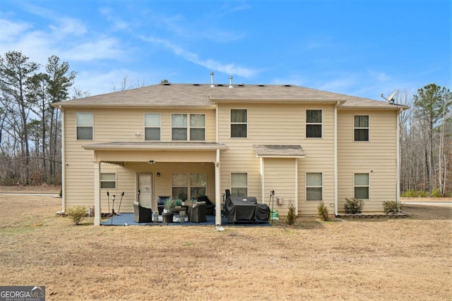 back of property with a yard and a patio area