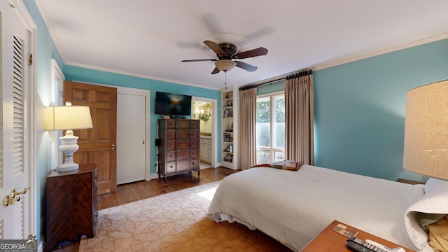 bedroom featuring dark wood-type flooring, ornamental molding, and ceiling fan