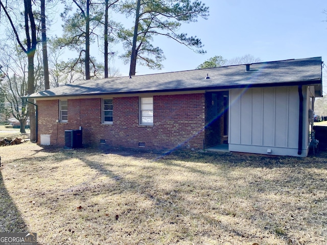 rear view of property with cooling unit and a lawn