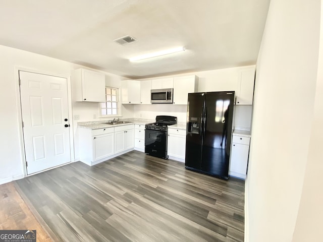 kitchen featuring dark wood-type flooring, sink, white cabinets, and black appliances