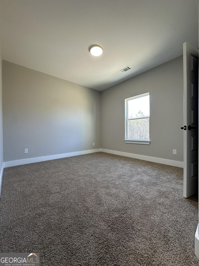 spare room with baseboards, visible vents, and carpet flooring