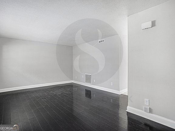 spare room with dark wood-type flooring and a textured ceiling