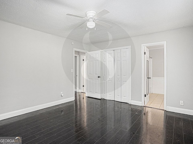 unfurnished bedroom featuring dark wood-type flooring and a textured ceiling