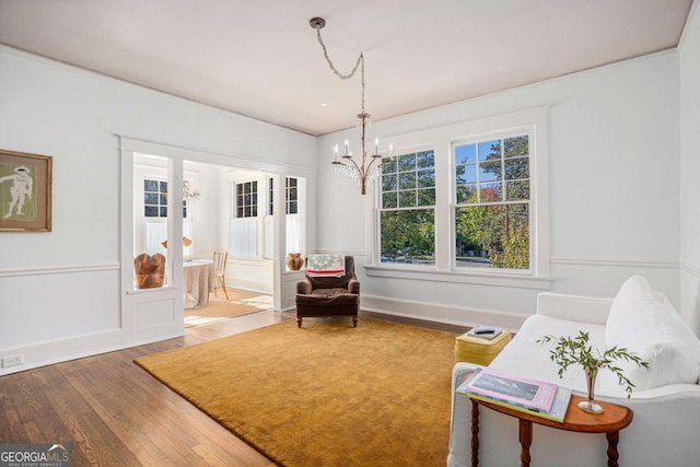 living area featuring wood-type flooring and an inviting chandelier