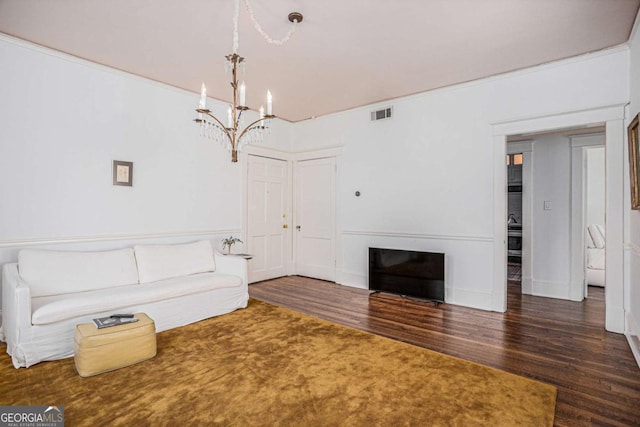 unfurnished living room featuring dark wood-type flooring, a chandelier, and a fireplace