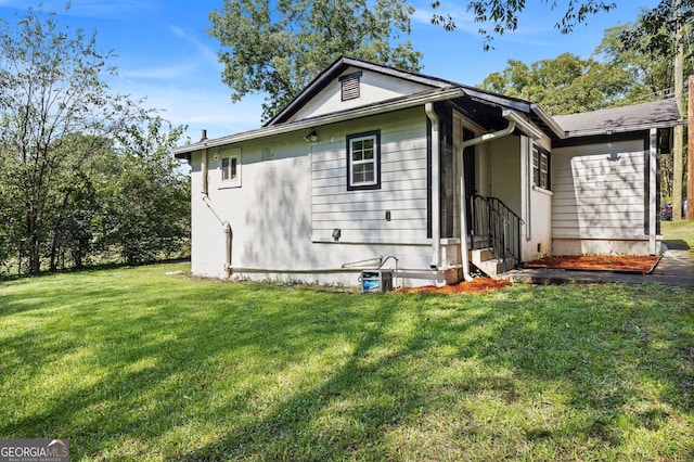 rear view of house featuring a lawn