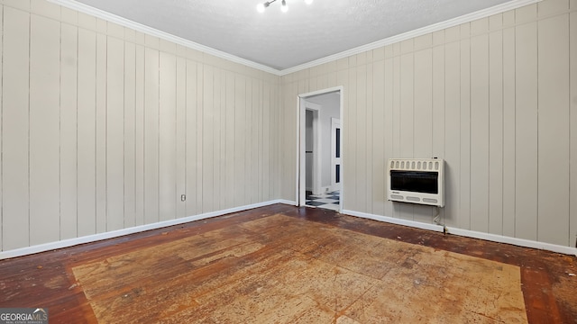 unfurnished living room featuring ornamental molding, wood-type flooring, and heating unit