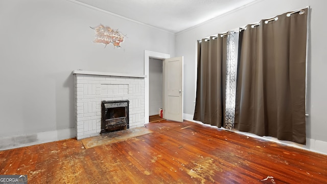 unfurnished living room featuring crown molding, a fireplace, and wood-type flooring