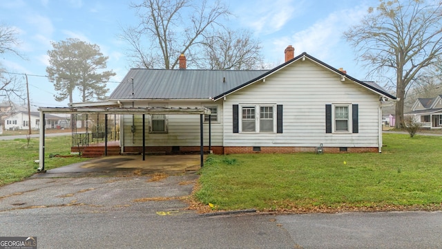 view of front of property with a carport and a front lawn