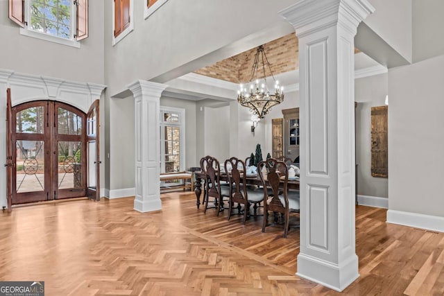 entrance foyer featuring plenty of natural light, decorative columns, french doors, and light parquet flooring